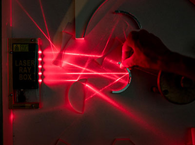 A hand interacting with a red laser experiment