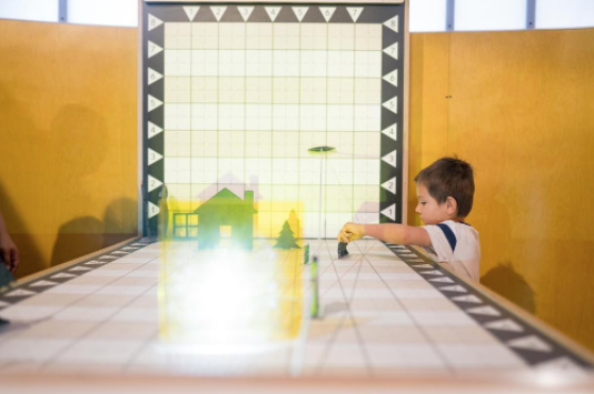 A child experiments with a hands-on-grid in the math exhibit.