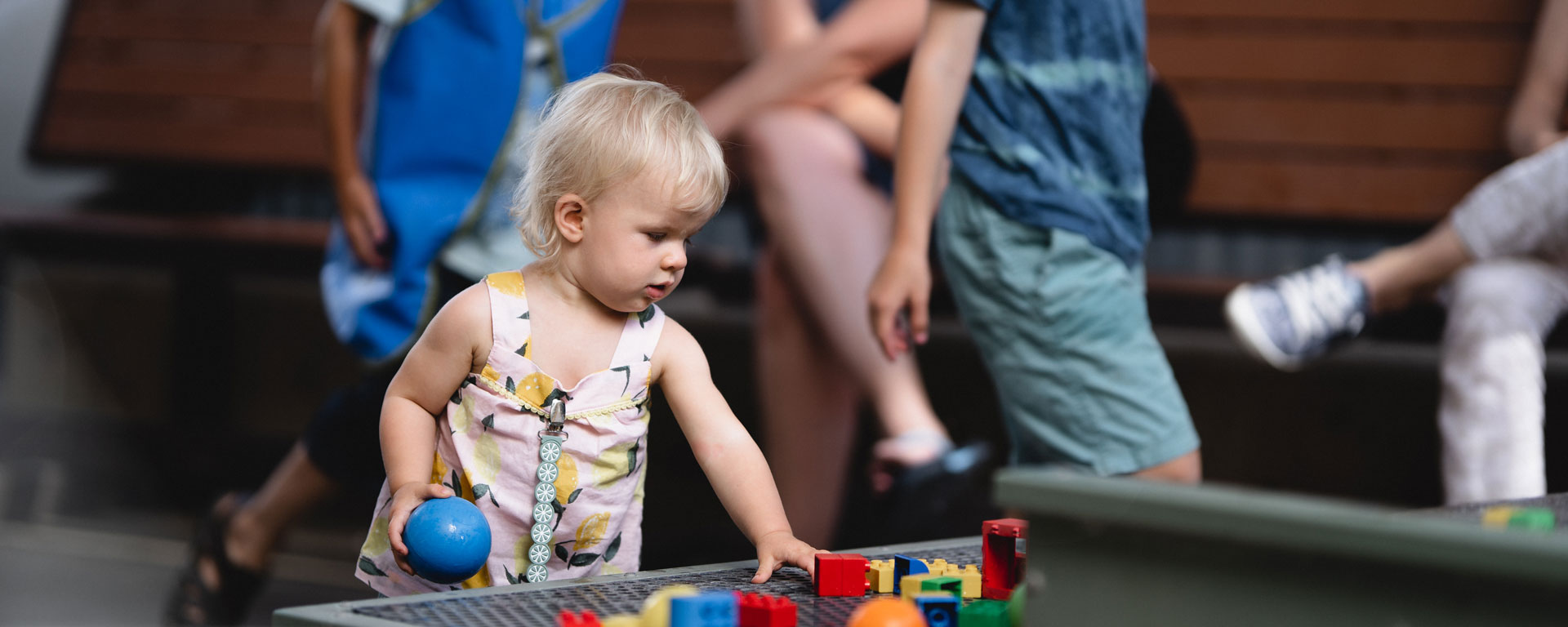 Decorative image of a very young child interacting with blocks and water